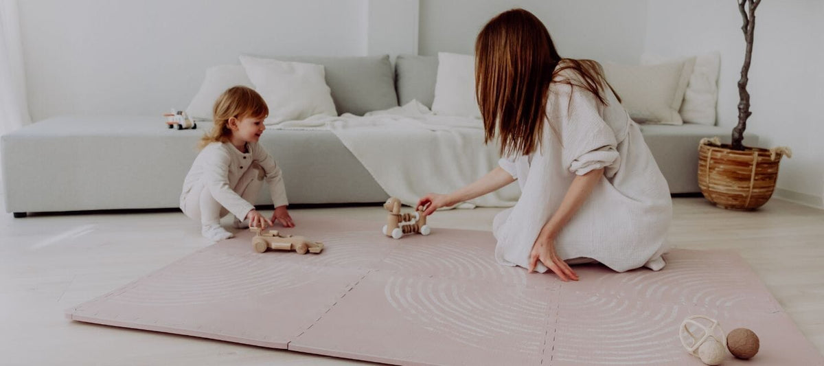 Mutter mit Kind am spielen auf der Puzzle Matte von emma & noah